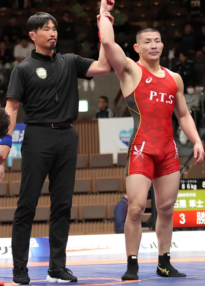 審判員が勝者の手を上げる写真